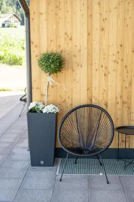 a bench next to a wooden fence with a potted plant at Chalet am Wiesenweg in Chiusa