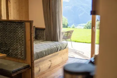 a room with a bed and a door to a patio at Chalet am Wiesenweg in Chiusa
