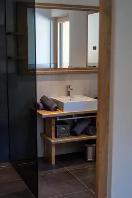 a bathroom with a sink and a mirror at Chalet am Wiesenweg in Chiusa