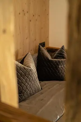 a bed with two pillows on it in a room at Chalet am Wiesenweg in Chiusa