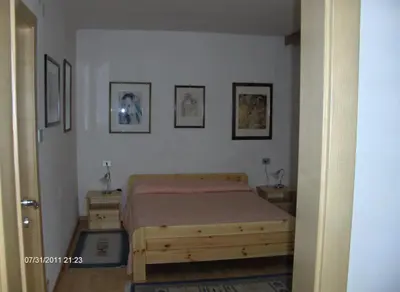 a bedroom with a bed and three pictures on the wall at villa mahlfertheiner in Castelrotto