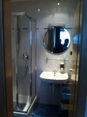 a bathroom with a shower and a sink and a mirror at villa mahlfertheiner in Castelrotto