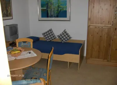 a living room with a table and a blue couch at villa mahlfertheiner in Castelrotto