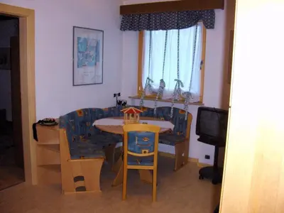 a living room with a table and chairs and a television at villa mahlfertheiner in Castelrotto