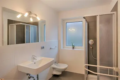 a bathroom with a sink and a toilet and a shower at Appartements Tirol in San Lorenzo di Sebato