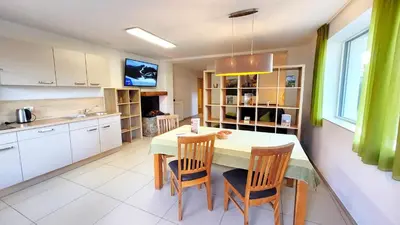 a kitchen with a table and chairs in a kitchen at Appartements Tirol in San Lorenzo di Sebato