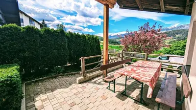 a table and a bench on a brick patio at Appartements Tirol in San Lorenzo di Sebato