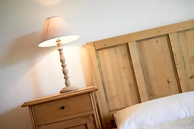 a lamp sitting on a night stand next to a bed at Weingut Stuck in Appiano sulla Strada del Vino