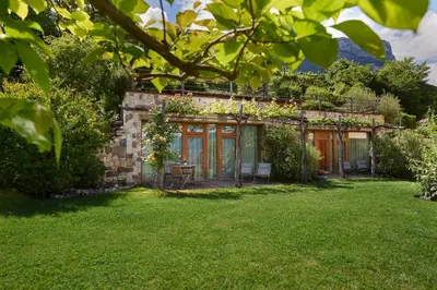 a stone house with a garden in the yard at Weingut Stuck in Appiano sulla Strada del Vino