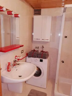a bathroom with a washing machine and a sink at Cèsa Pier Sellaronda Dolomiti in Campitello di Fassa