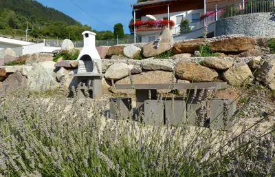 a garden with a stone wall and a bench at Residence Liesy in Tesimo