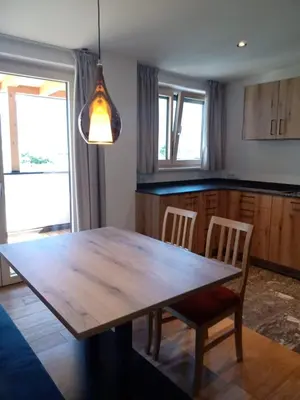 a dining room with a wooden table and chairs at Mittelbergerhof Ferienwohnungen in Vilpiano