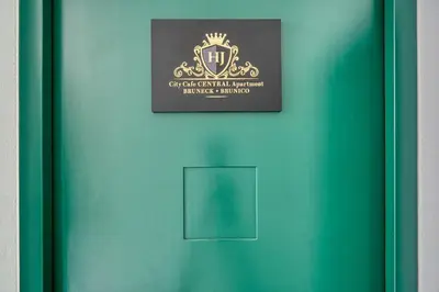 a green door with a sign on it at City Café - CENTRAL Apartment in Brunico