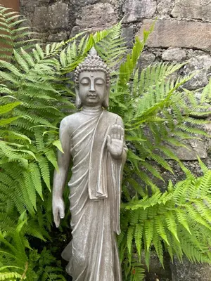 a statue of a buddha in front of leaves at Alpine Chalet CESA VEDLA -nature & silence in Ortisei