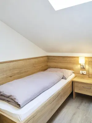 a bedroom with a large bed and a table at Hotel Sonnenheim in Vipiteno