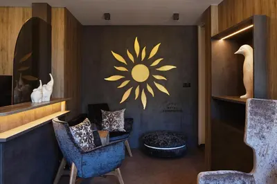 a room with two chairs and a flower on the wall at Hotel Sonnenheim in Vipiteno
