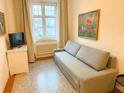 a living room with a couch and a television at Cozy city center apartment in Bolzano