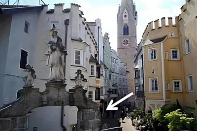 a white house with a balcony on top of a yard at Downtown Hideout Bressanone Pedestrian Zone Private Garden, Parking Brixen Card in Bressanone