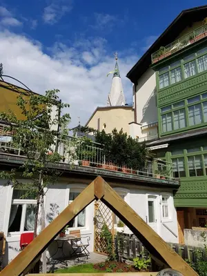 a room with a fireplace and a bed and a chair at Downtown Hideout Bressanone Pedestrian Zone Private Garden, Parking Brixen Card in Bressanone