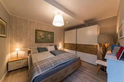 a bed in a bedroom with a painting on the wall at Downtown Hideout Bressanone Pedestrian Zone Private Garden, Parking Brixen Card in Bressanone