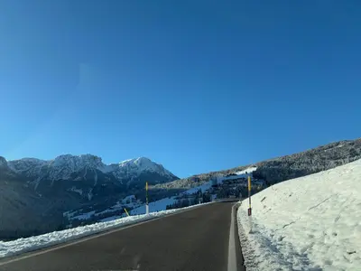 an empty road with snow on the side of a mountain at Appartements Schatzer in Valdaora