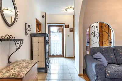 a living room with a couch and a mirror at Dimora Franch Cloz Ospitar in Cloz