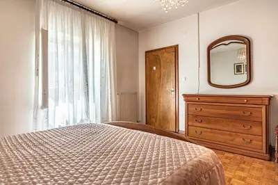 a bedroom with a bed and a mirror and a dresser at Dimora Franch Cloz Ospitar in Cloz