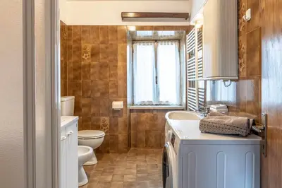 a bathroom with a sink and a toilet and a window at Dimora Franch Cloz Ospitar in Cloz