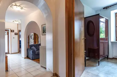 a hallway with an archway leading to a living room at Dimora Franch Cloz Ospitar in Cloz
