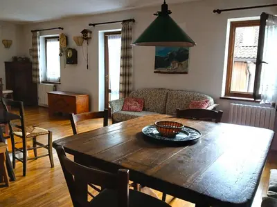 a living room with a wooden table and a couch at Casa Rosetta nel cuore delle Dolomiti in Tonadico