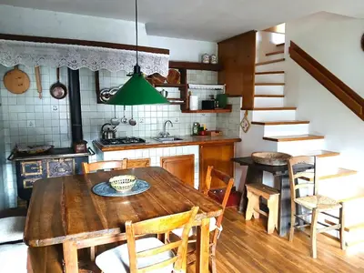 a kitchen and dining room with a wooden table and chairs at Casa Rosetta nel cuore delle Dolomiti in Tonadico