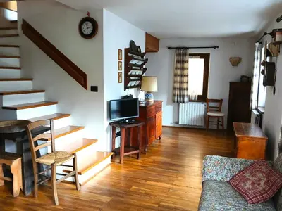 a living room with a staircase and a couch at Casa Rosetta nel cuore delle Dolomiti in Tonadico