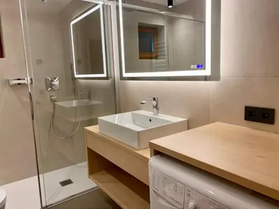 a bathroom with a sink and a shower at Ciasa La Rösa in Badia