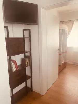 a room with a book shelf and a flat screen tv at Braunegg 1 in Brunico