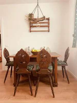 a wooden dining room table with two chairs and a tablewered at Braunegg 1 in Brunico