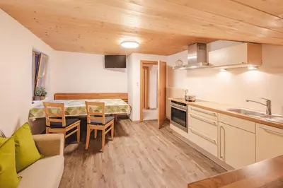 a kitchen with a table and a dining room at Reden Hof in Selva dei Molini