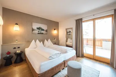 a hotel room with a large bed and a window at Hotel Bischofhof in Chiusa