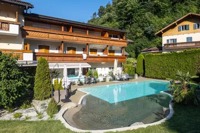 a house with a swimming pool in front of it at Hotel Bischofhof in Chiusa