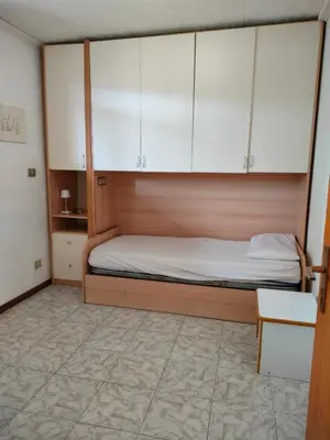 a kitchen with white cabinets and a sink and a microwave at TERRAZZA SULLE DOLOMITI in Castello di Fiemme