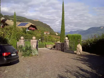 a car parked in front of a driveway with a gate at Huebenburg in Appiano sulla Strada del Vino