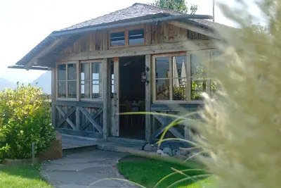 a wooden house with glass doors in a garden at Huebenburg in Appiano sulla Strada del Vino