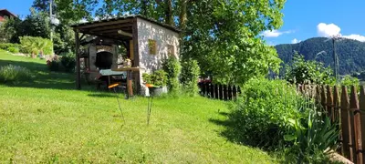 an old building in the grass with a fence at Waldhof in Meltina