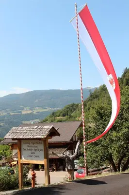 a person holding a flag in front of a building at Verleierhof in Castelrotto