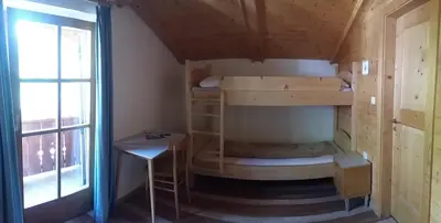 a room with bunk beds and a table and a window at Verleierhof in Castelrotto
