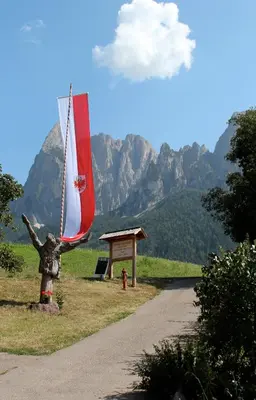 a statue of a person standing next to a road at Verleierhof in Castelrotto