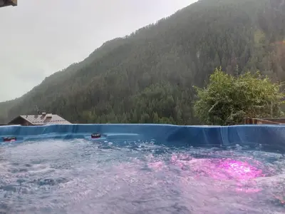 a pool of water with a mountain in the background at Italian Apartment with Hot Tub in Arabba