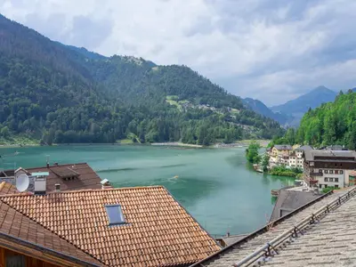 a view of a river with houses and mountains at Hotel Alle Alpi in Alleghe