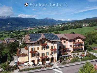 a building with solar panels on its roof at Wellness e Resort Stella Delle Alpi in Ronzone