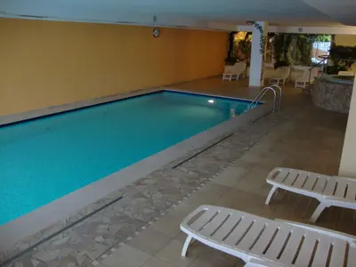 a swimming pool with two chaise pits and a pool at Wellness e Resort Stella Delle Alpi in Ronzone