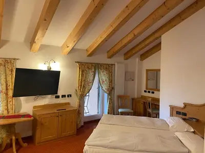 a bedroom with a bed and a flat screen tv at Wellness e Resort Stella Delle Alpi in Ronzone